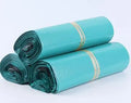 A bundle of 100 flat, clear PE plastic courier bags for clothing with adhesive sticker seals.