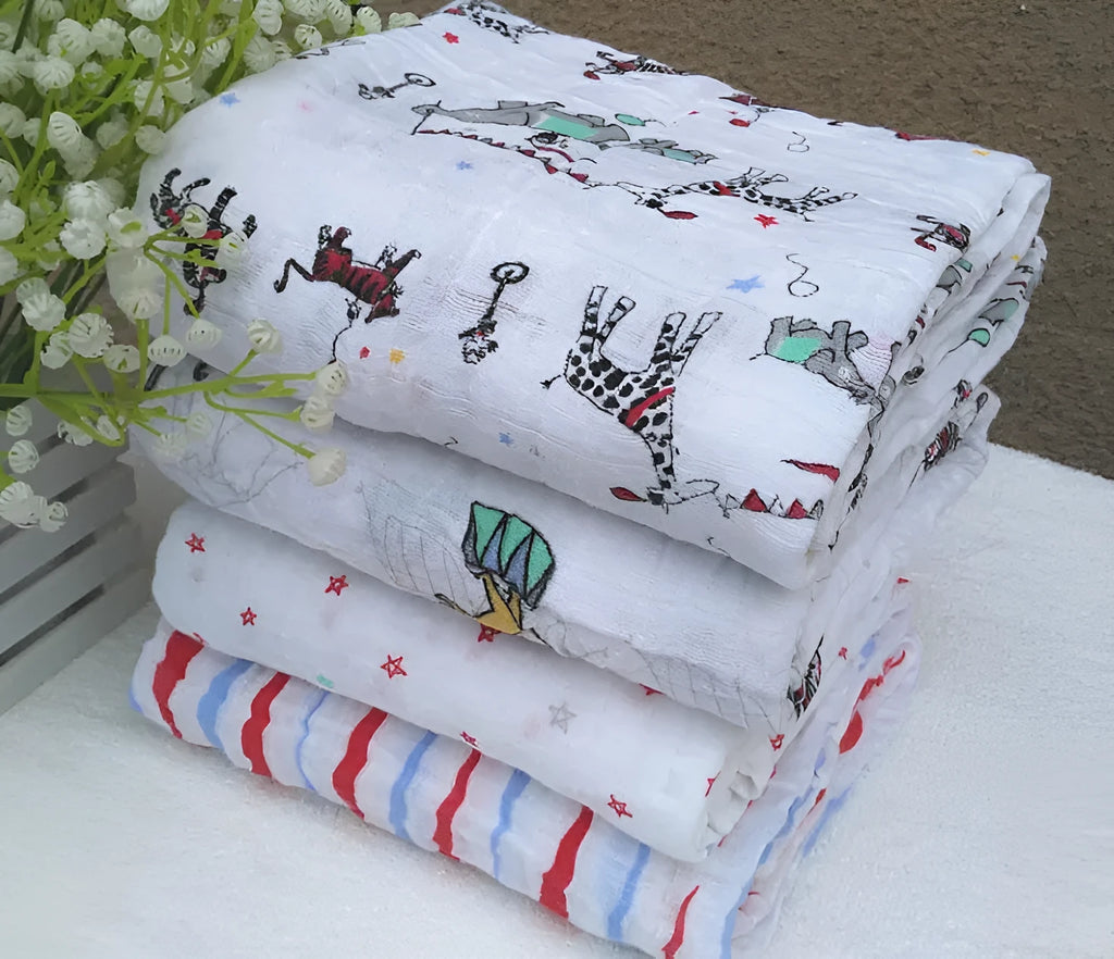 Cotton gauze baby blanket 120x120cm in balloon elephant style folded on a light background