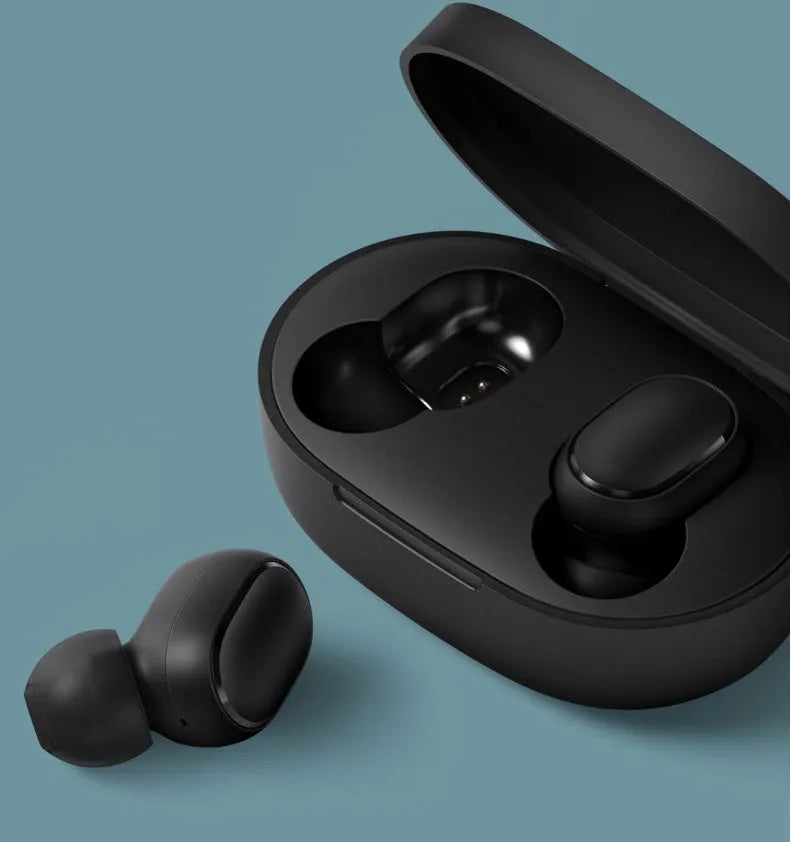 Redmi AirDots black true wireless earbuds and charging case on a table.