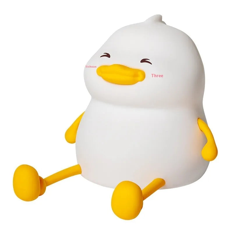 Chubby silicone desk night lamp with integrated mobile phone holder showing soft glowing light.