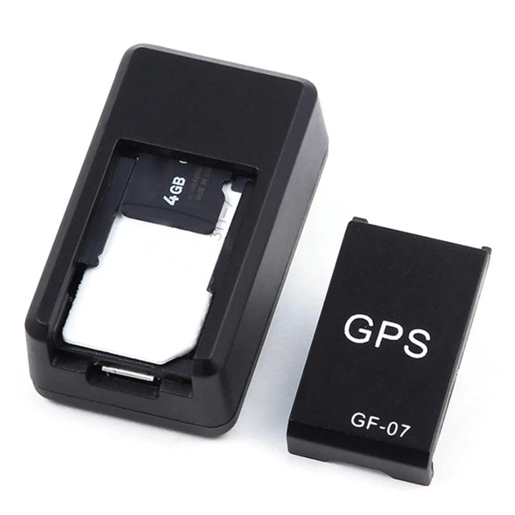Small black plastic magnetic GPS car tracker device with USB cable.