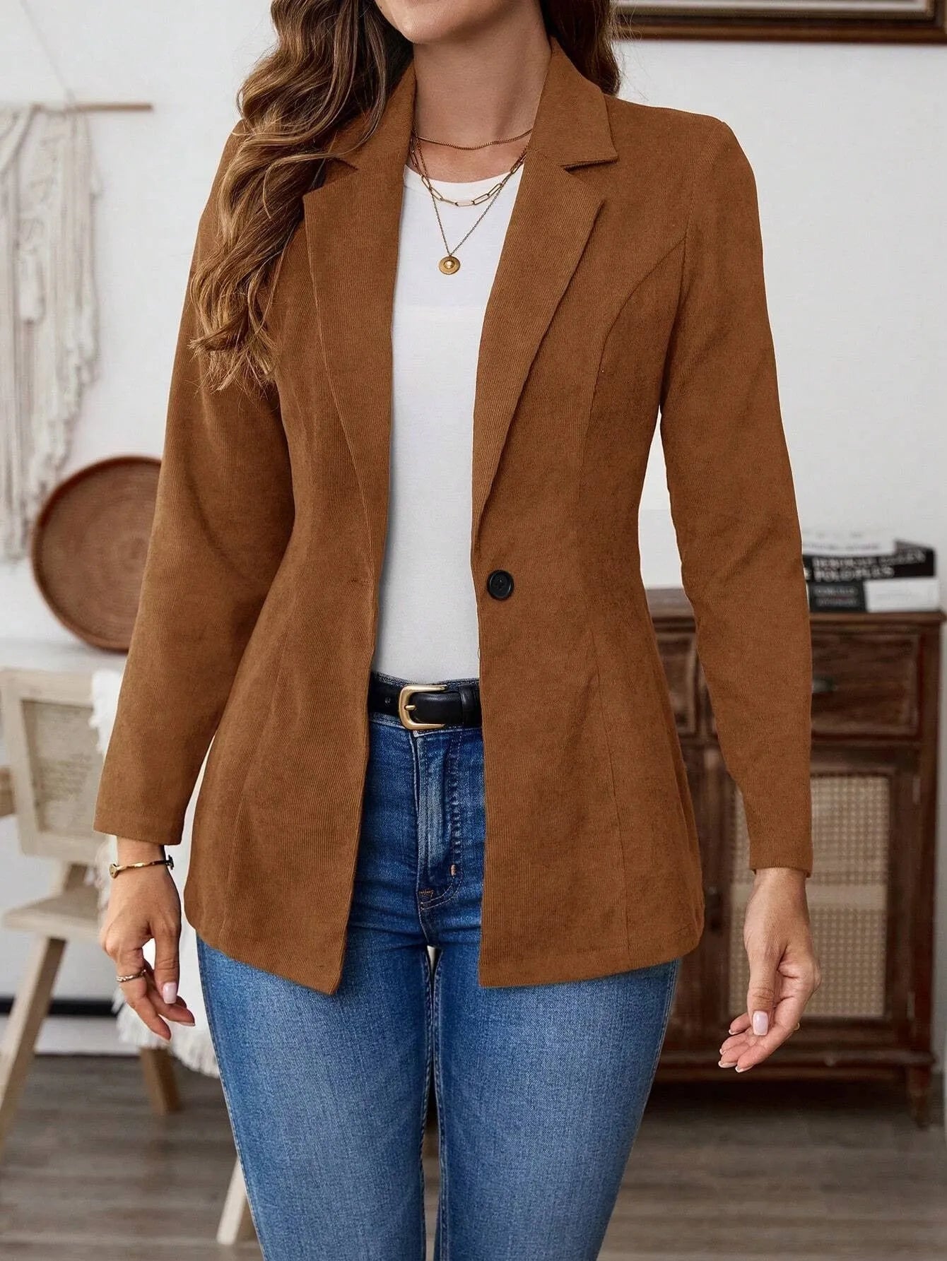 Brown long sleeve single-breasted suit coat with lapel collar on a hanger.