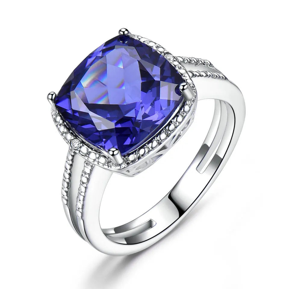 Blue tanzanite stone set in a sterling silver women's ring on a white background.