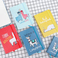 Alpaca cartoon design notepad open showing yellow paper, available in A5, A6, and A7 sizes.