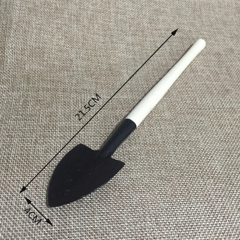 Succulent gardening tool set showing watering can, mini shovel, rake, tweezers, and small brush for plant care.