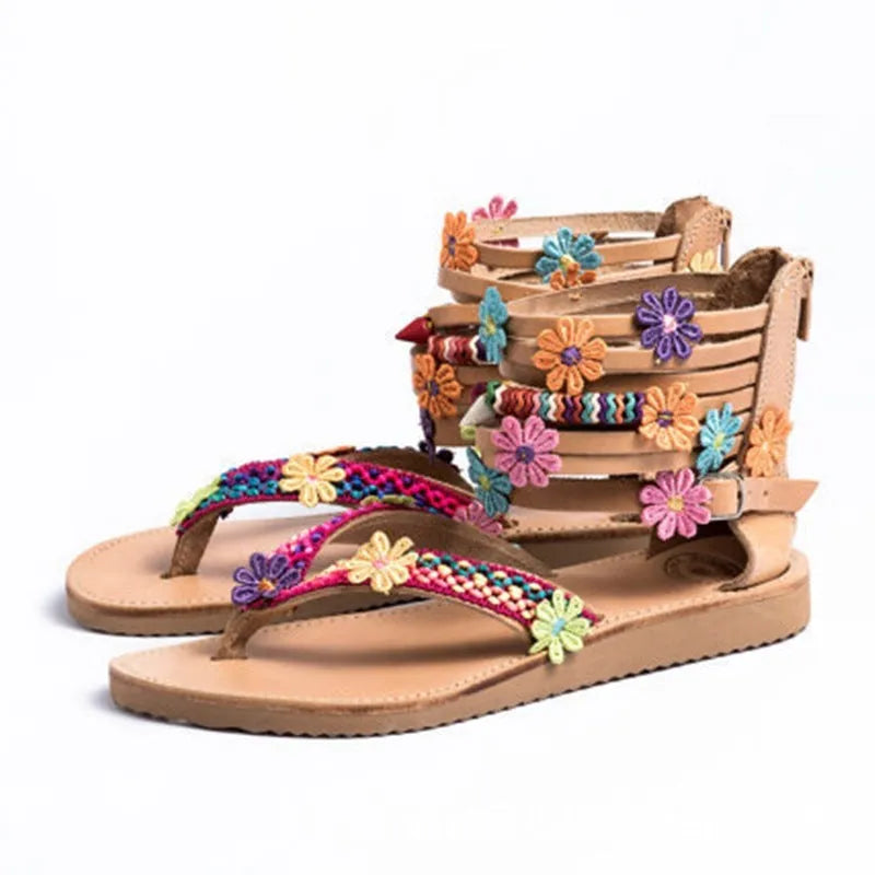 Ethnic style beaded petal sandals with floral decoration and round toe on a white background.