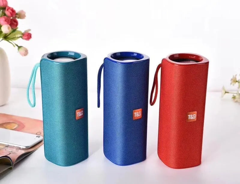 Wireless Bluetooth speaker with cloth cover in multiple colours showing front speaker grille and control buttons