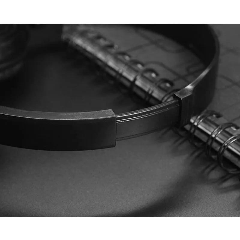 Black folding wired over-ear headphones with adjustable headband and 3.5mm plug on a coiled cable.