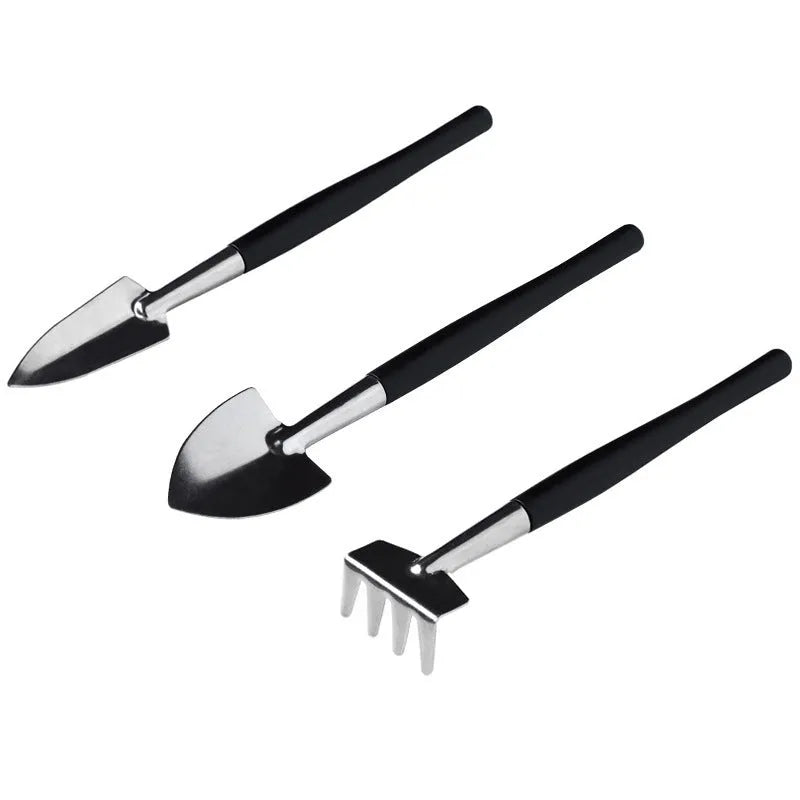 Black mini succulent garden tool set with 14 pieces including tweezers, shovel, spray bottle, and a square cushion laid out.