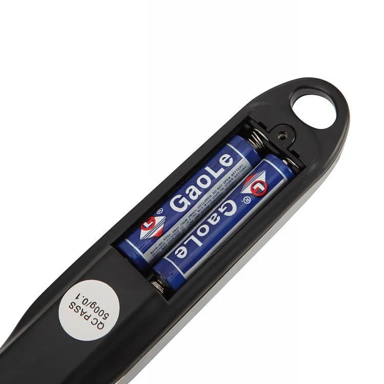 Smart digital measuring spoon with LCD display showing weight, used as a kitchen scale for food ingredients.