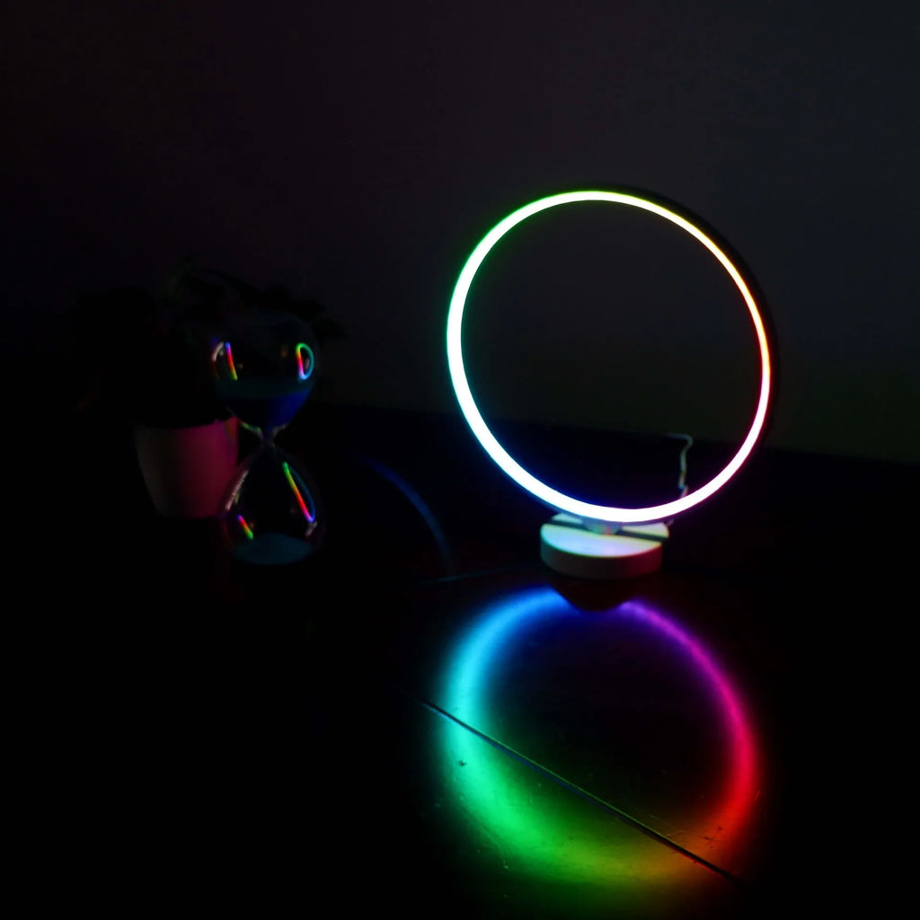 White spherical Full Moon table lamp with remote control on a wooden surface.