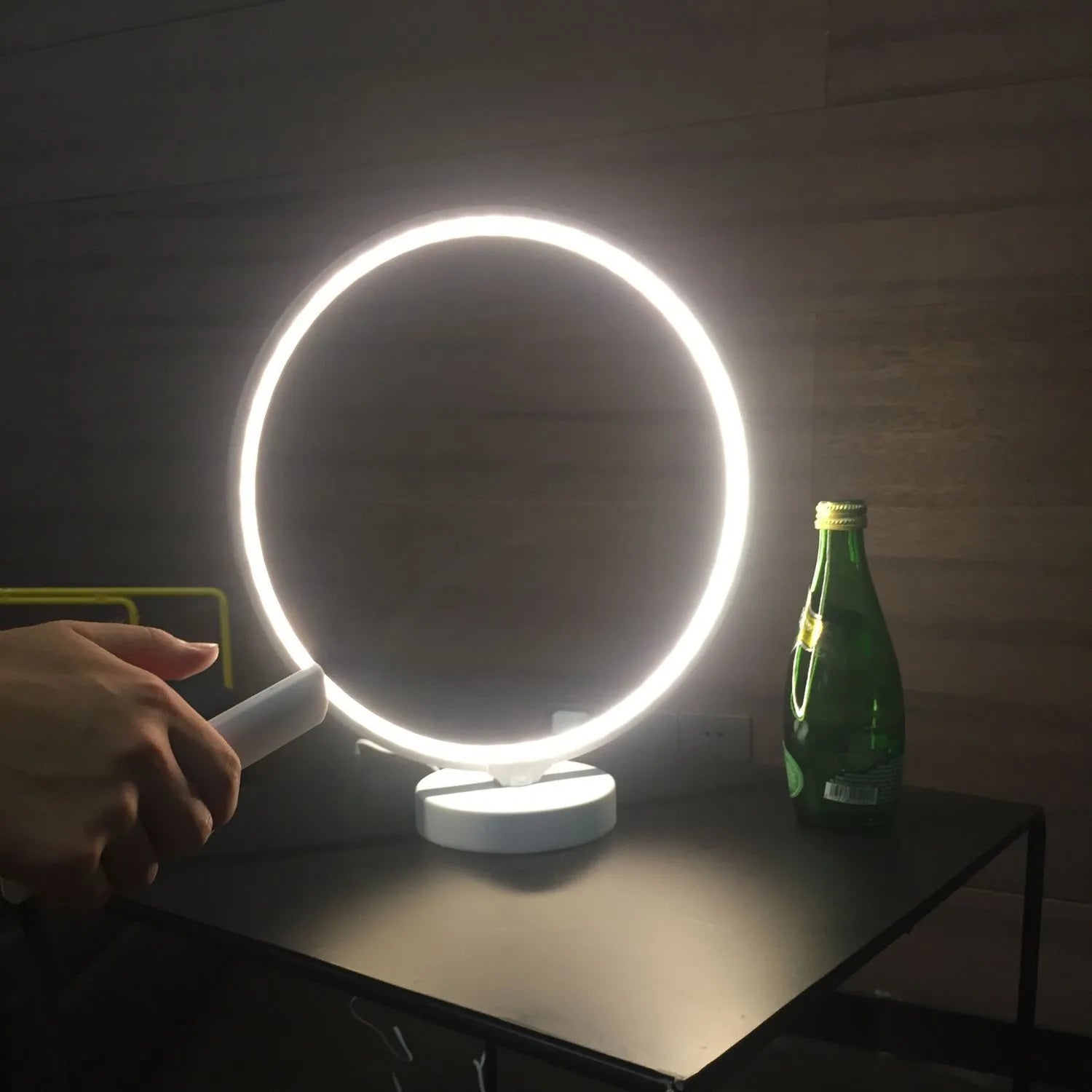 White spherical Full Moon table lamp with remote control on a wooden surface.