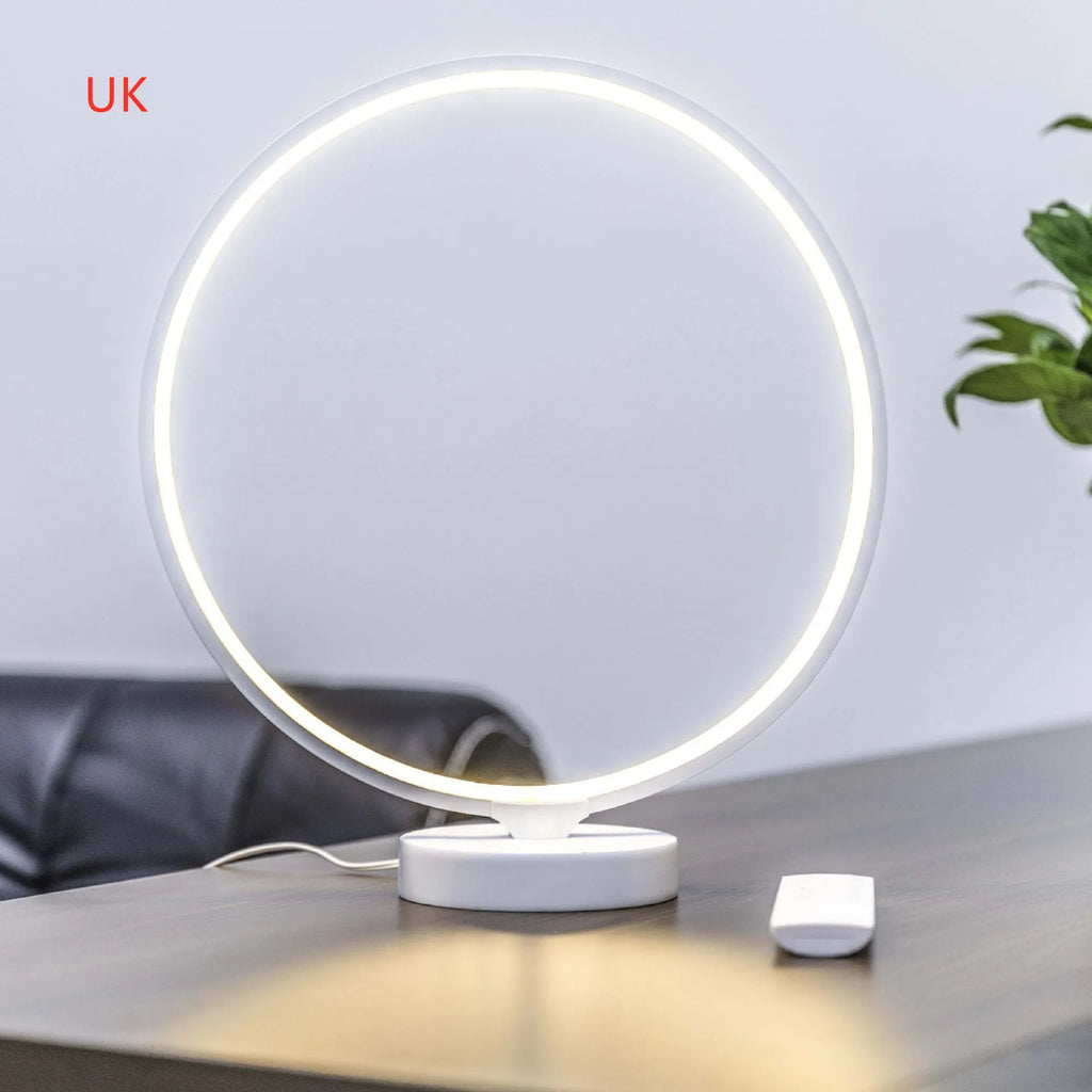 White spherical Full Moon table lamp with remote control on a wooden surface.