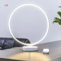 White spherical Full Moon table lamp with remote control on a wooden surface.