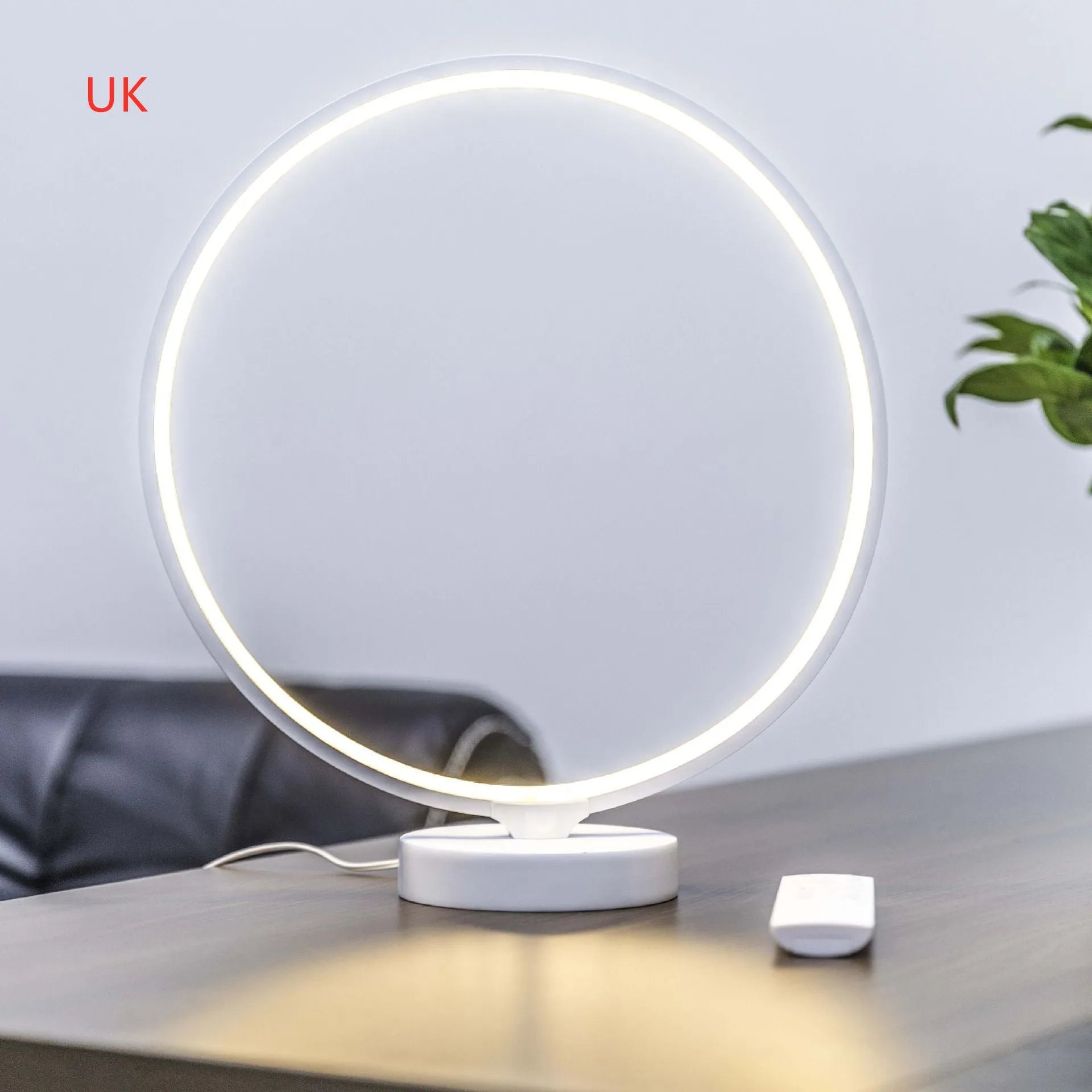 White spherical Full Moon table lamp with remote control on a wooden surface.