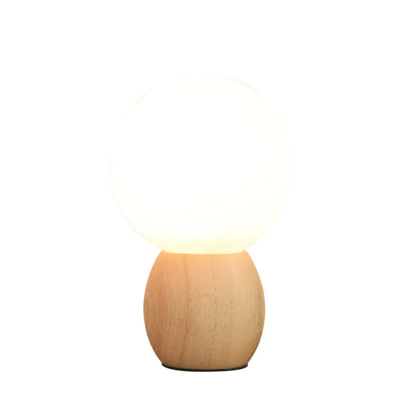 Nordic style glass ball table lamp with LED lighting on wooden surface