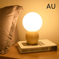 Nordic style glass ball table lamp with LED lighting on wooden surface