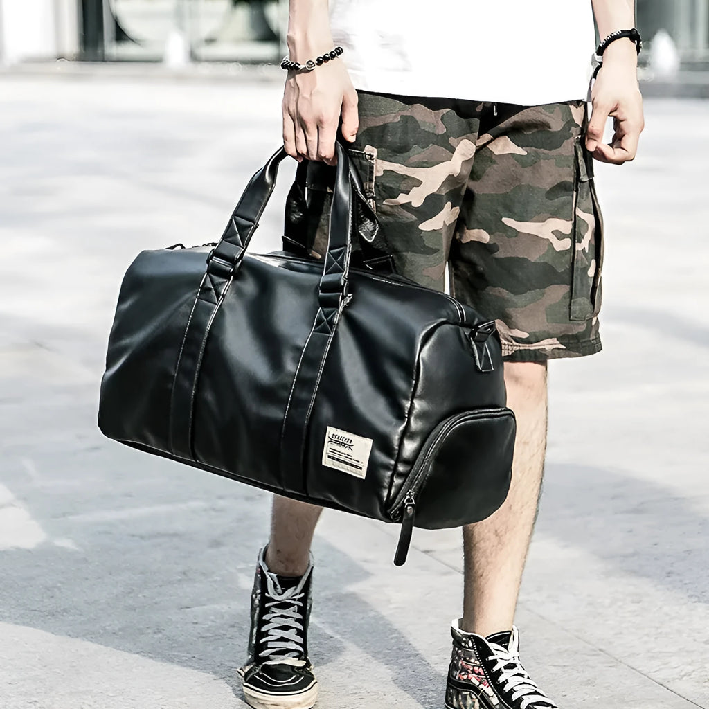 Black large capacity PU leather sports training bag with single strap and multiple internal pockets.