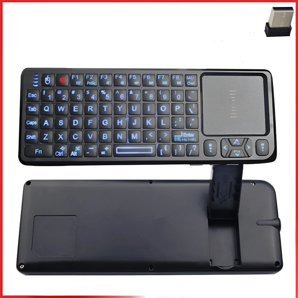 Black wireless mini keyboard with touch screen and laser pointer on a desk next to a laptop