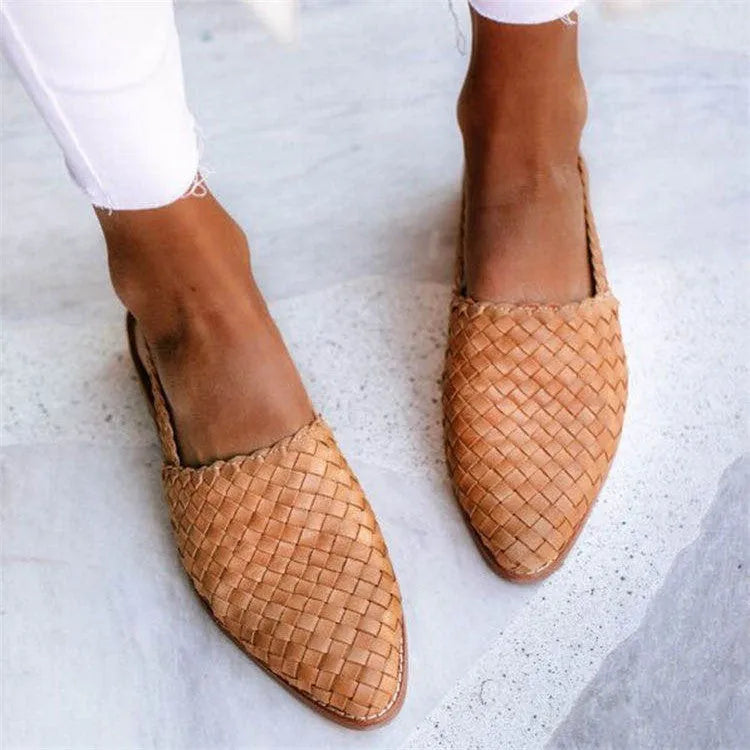Flat pointed toe sandals with a silver buckle on a microfiber upper.
