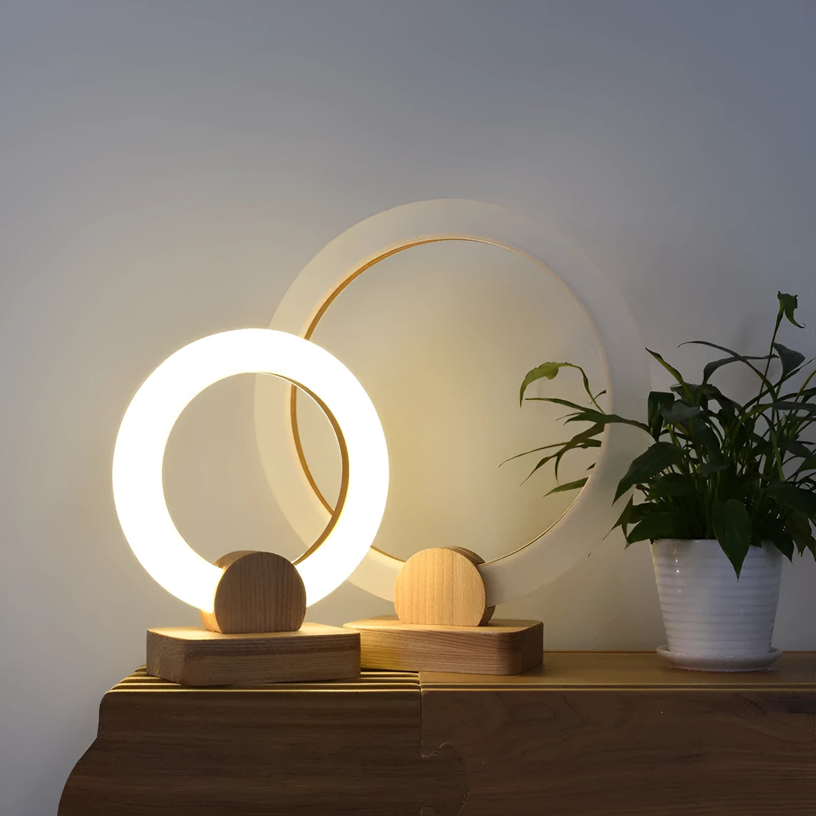 Nordic style circular wooden chandelier with a white acrylic shade hanging from a ceiling.