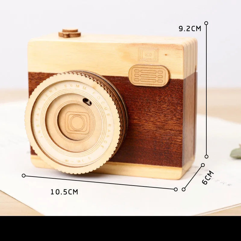 Camera-shaped wooden music box rotating on wooden surface with pine wood construction
