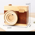 Camera-shaped wooden music box rotating on wooden surface with pine wood construction