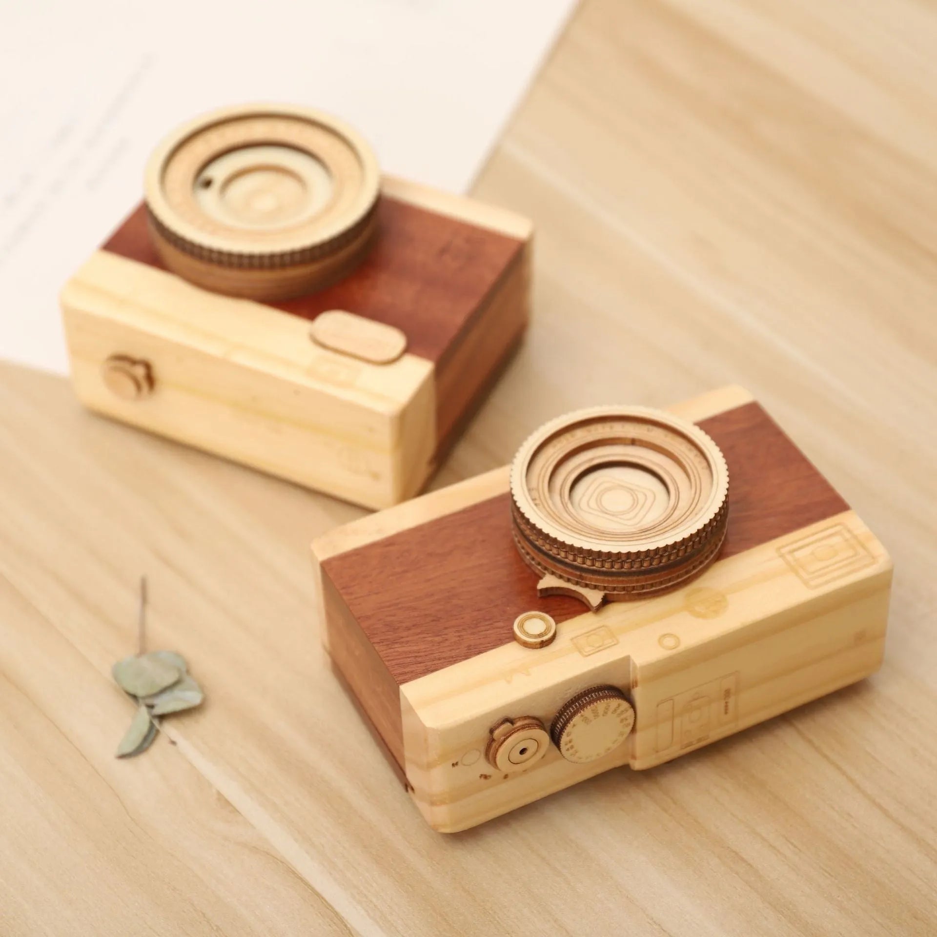 Camera-shaped wooden music box rotating on wooden surface with pine wood construction