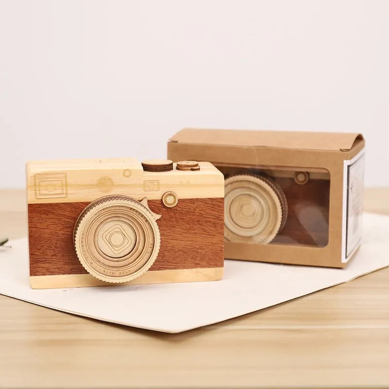 Camera-shaped wooden music box rotating on wooden surface with pine wood construction
