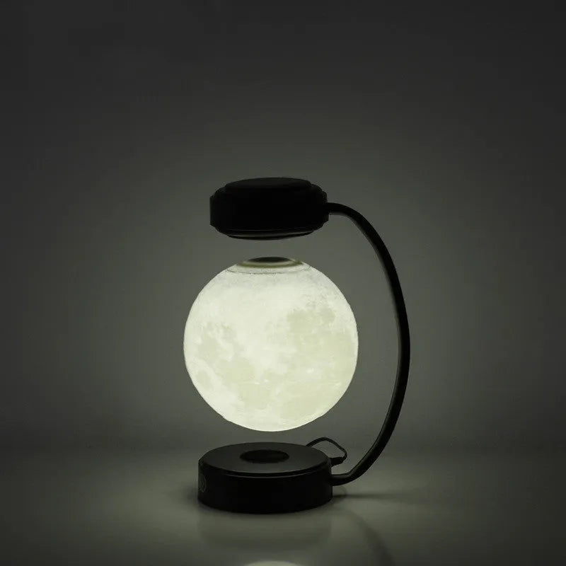 Black and gold magnetic levitation moon lamp floating above base with touch controls