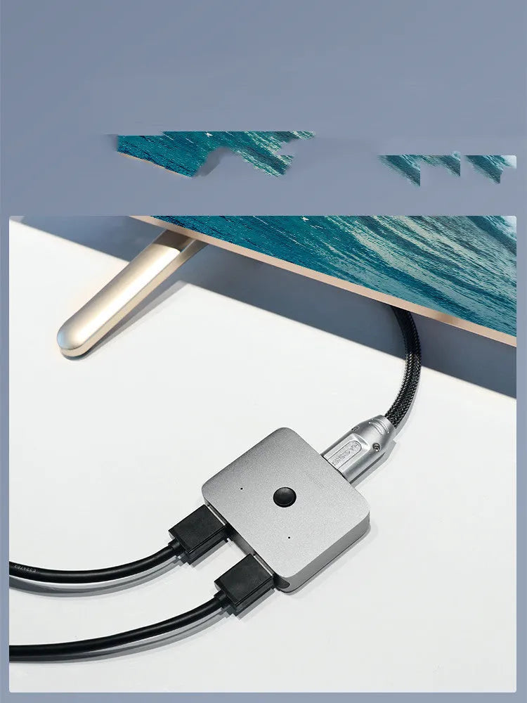 Grey Haibeisi HDMI switcher box showing one input and two output ports for splitting a video signal to two screens.