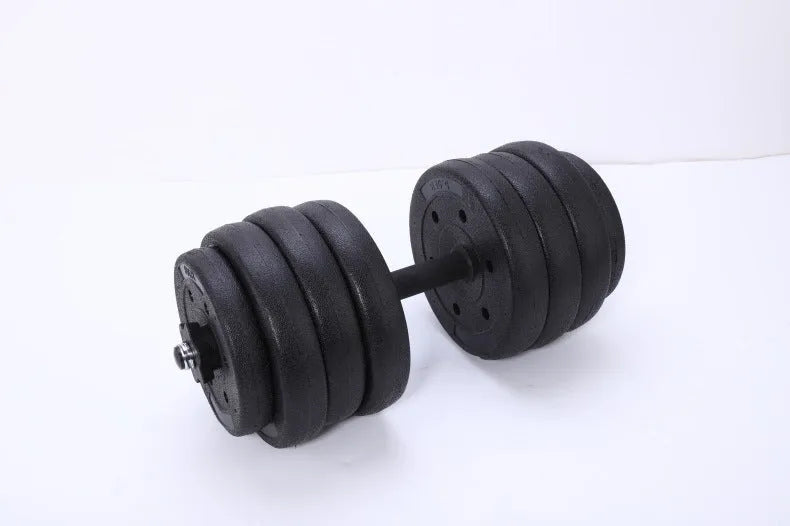Pair of black rubber coated round head dumbbells 10kg each on a gym floor with indoor fitness equipment