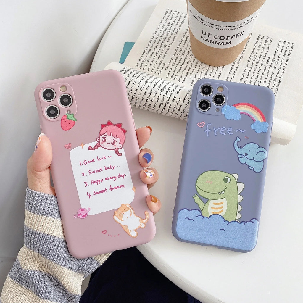 Blue frosted soft shell iPhone case with cartoon dinosaur print next to pink case with cat girl print.