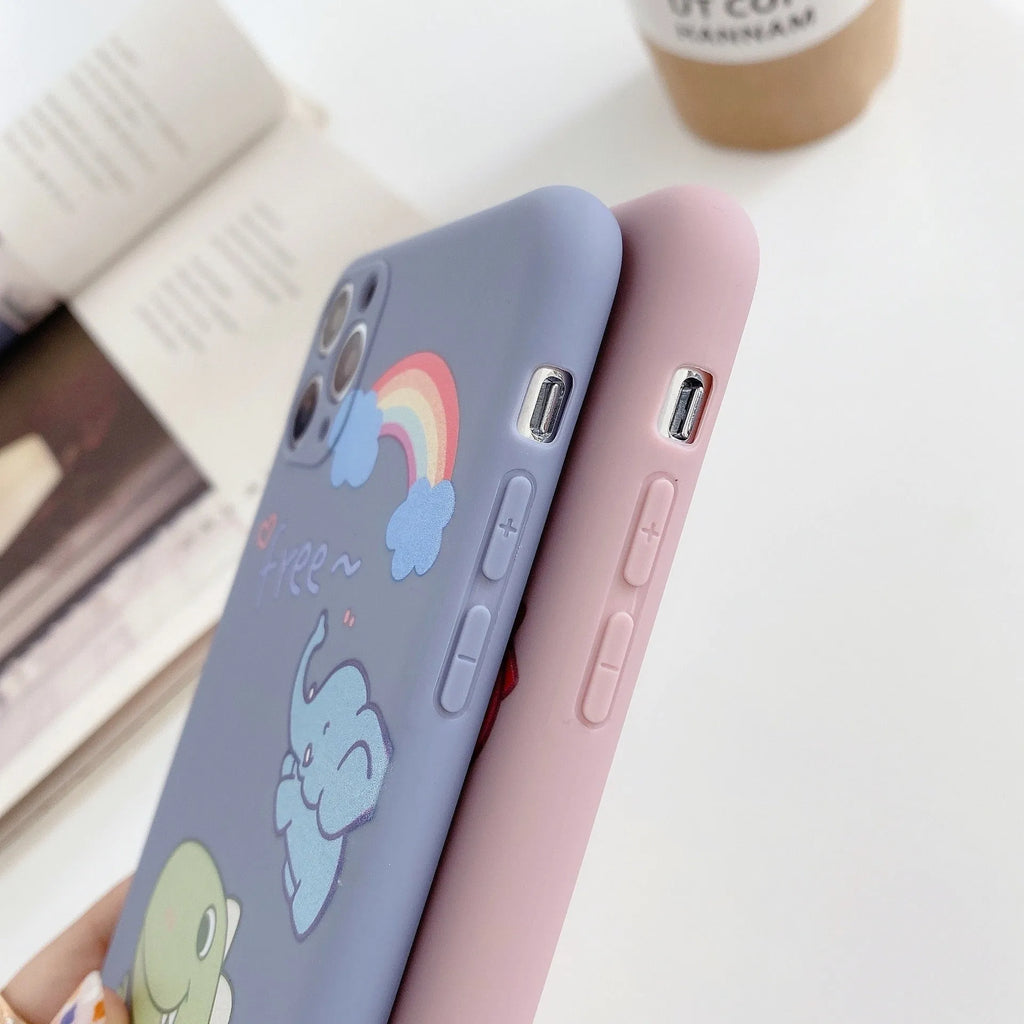 Blue frosted soft shell iPhone case with cartoon dinosaur print next to pink case with cat girl print.