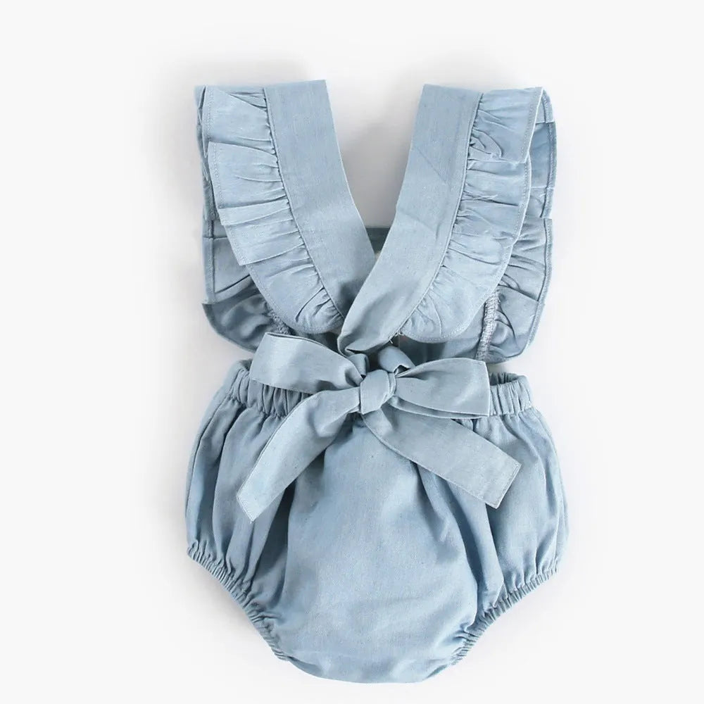 Blue denim sleeveless baby romper with lace trim on a hanger