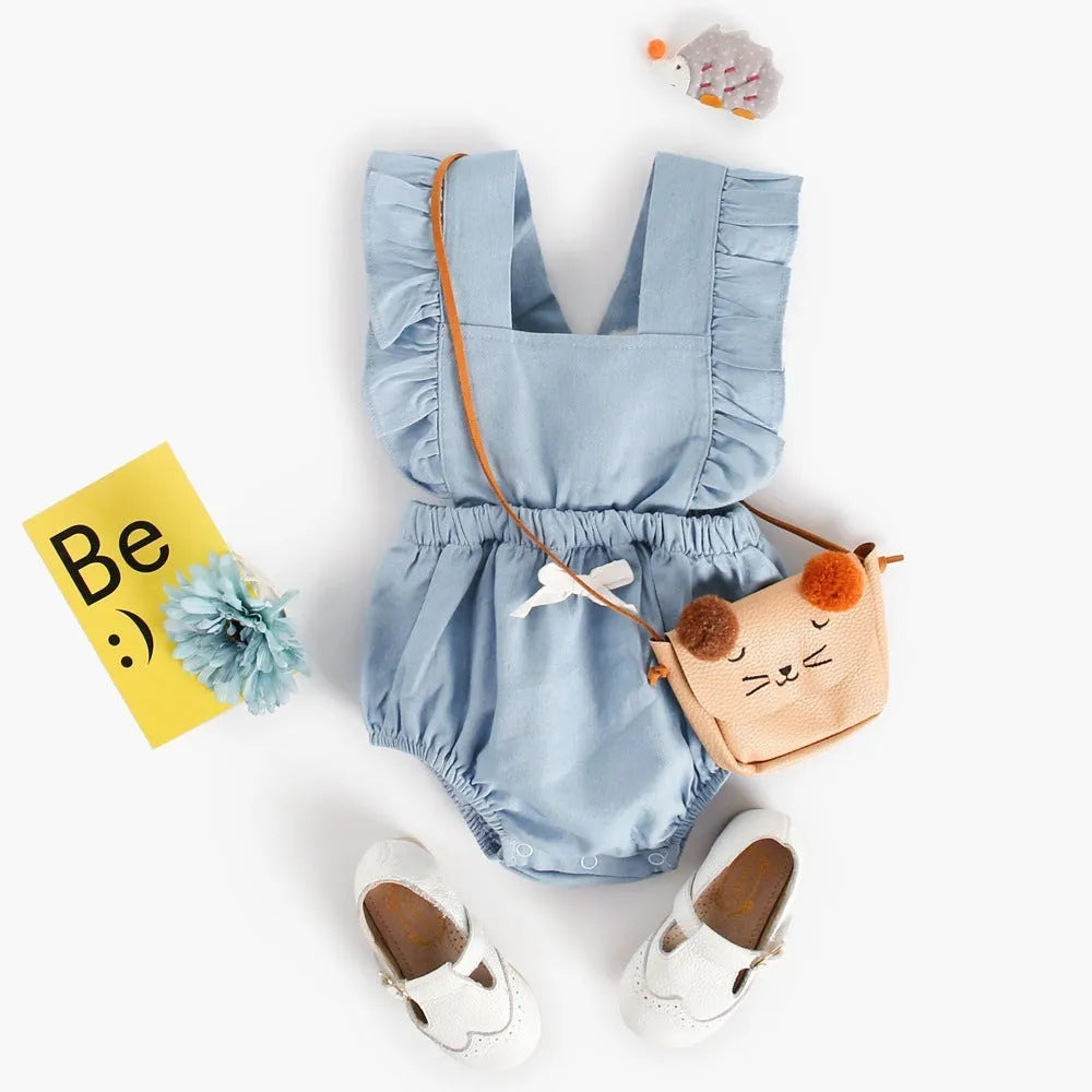 Blue denim sleeveless baby romper with lace trim on a hanger