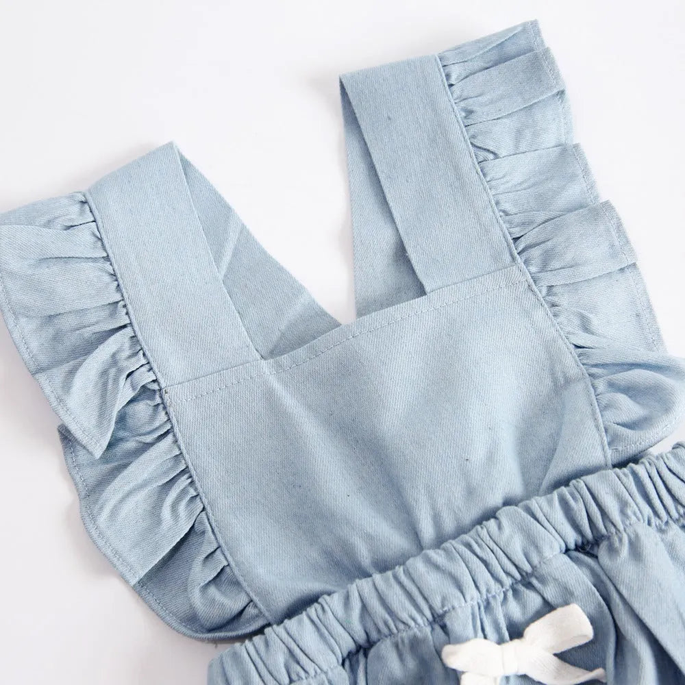 Blue denim sleeveless baby romper with lace trim on a hanger