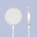 Silver metal Magsafe wireless charger for iPhone on a wooden surface.