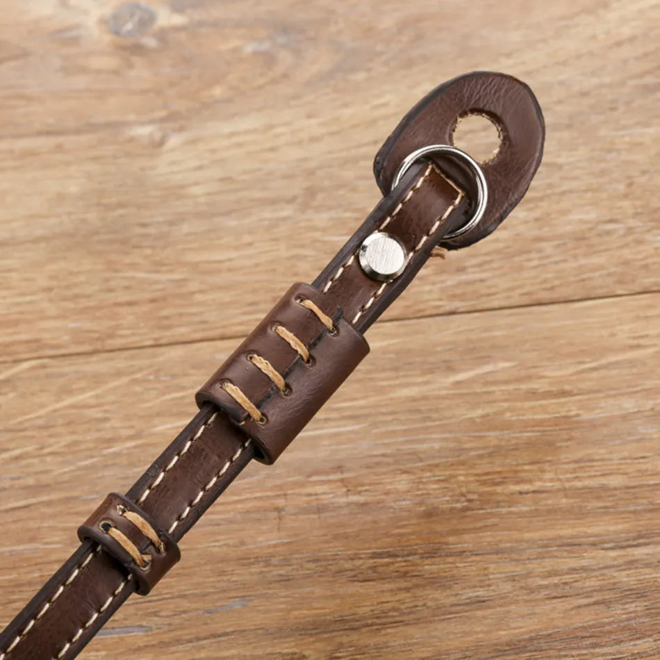 Black camera wrist strap with quick-release buckle attached to camera lug
