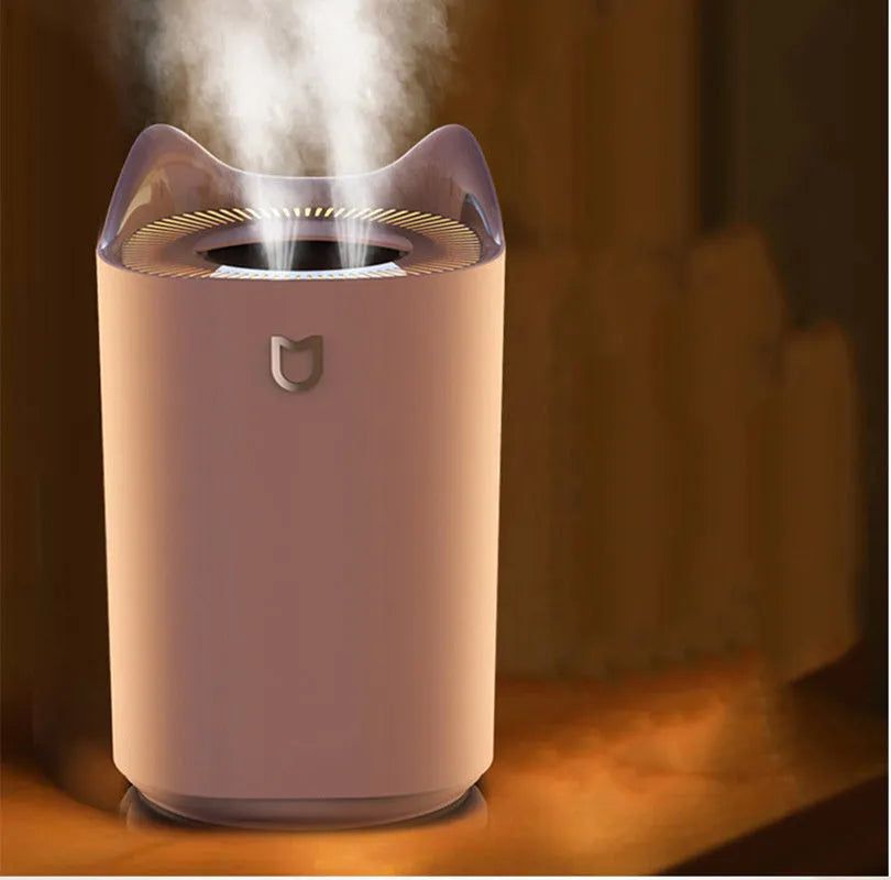 Coral Pink USB-powered humidifier and aroma diffuser with three mist outlets on a wooden table.