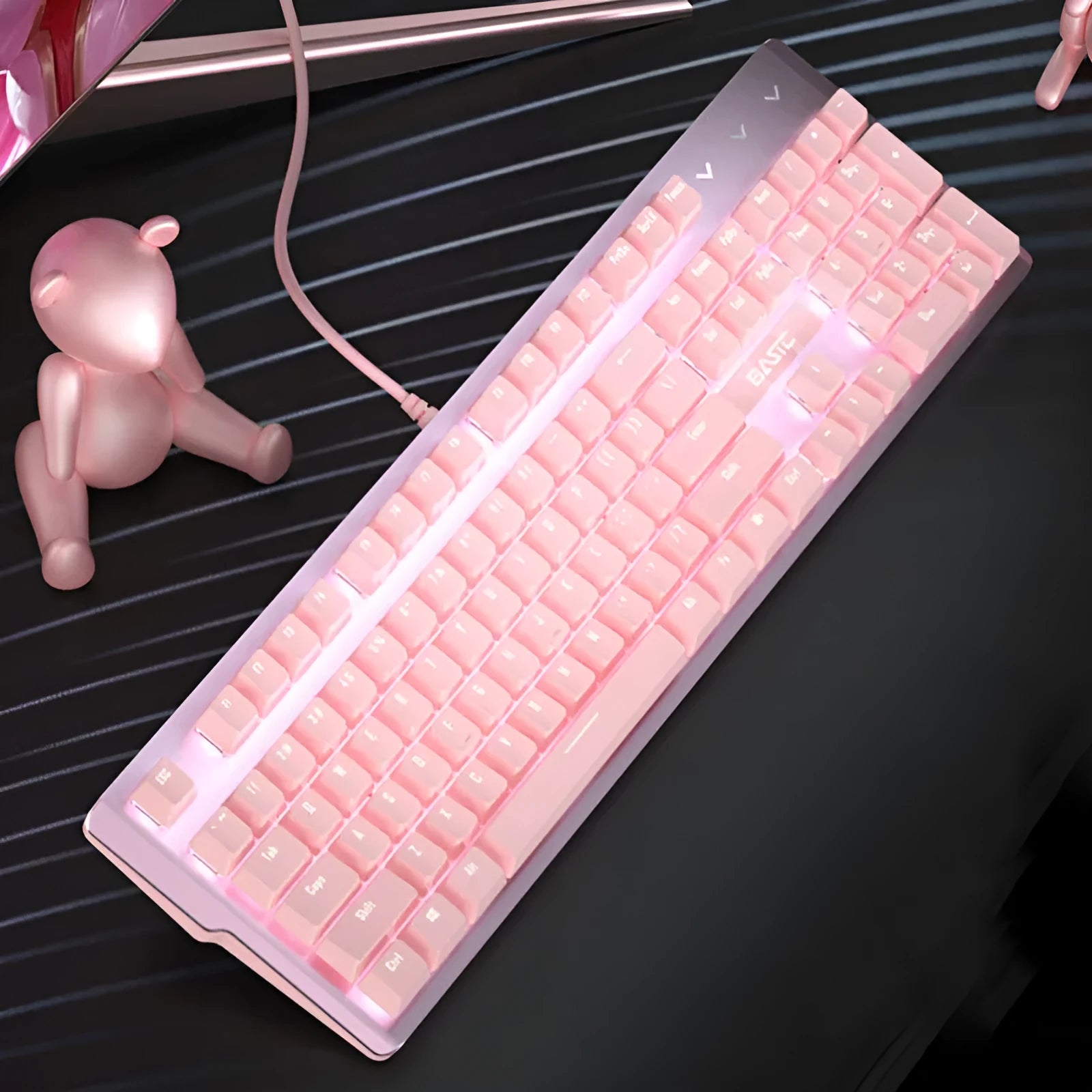 Pink coloured mechanical keyboard and wired mouse set on a desk.
