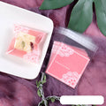 Pink self-adhesive plastic packaging bags with UV printing, shown in a pack of 100.