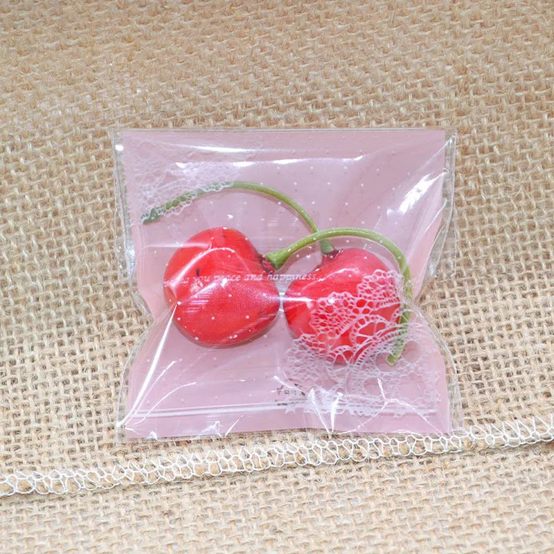 Pink self-adhesive plastic packaging bags with UV printing, shown in a pack of 100.