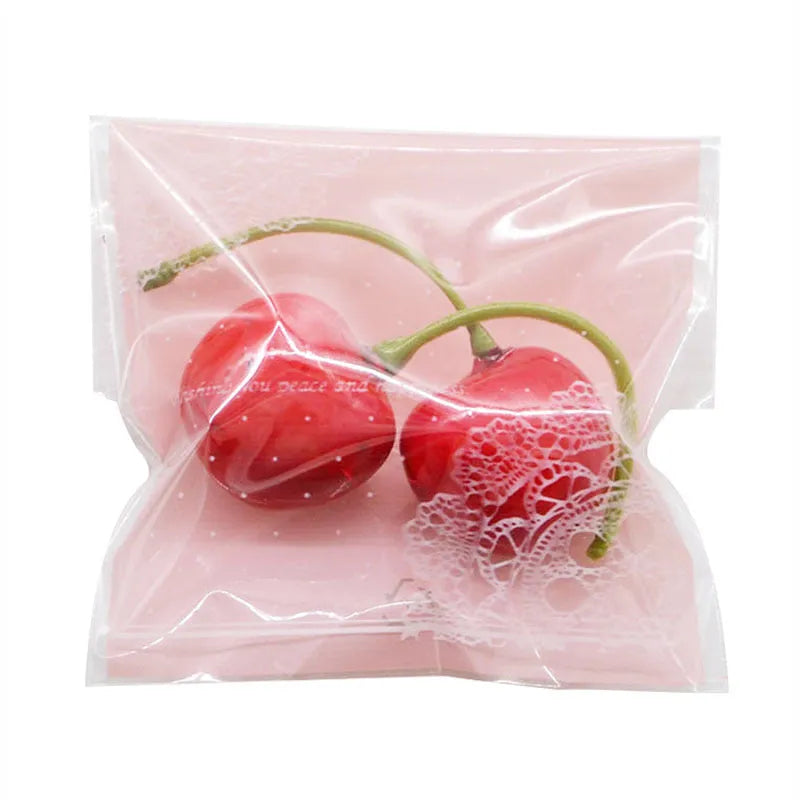 Pink self-adhesive plastic packaging bags with UV printing, shown in a pack of 100.