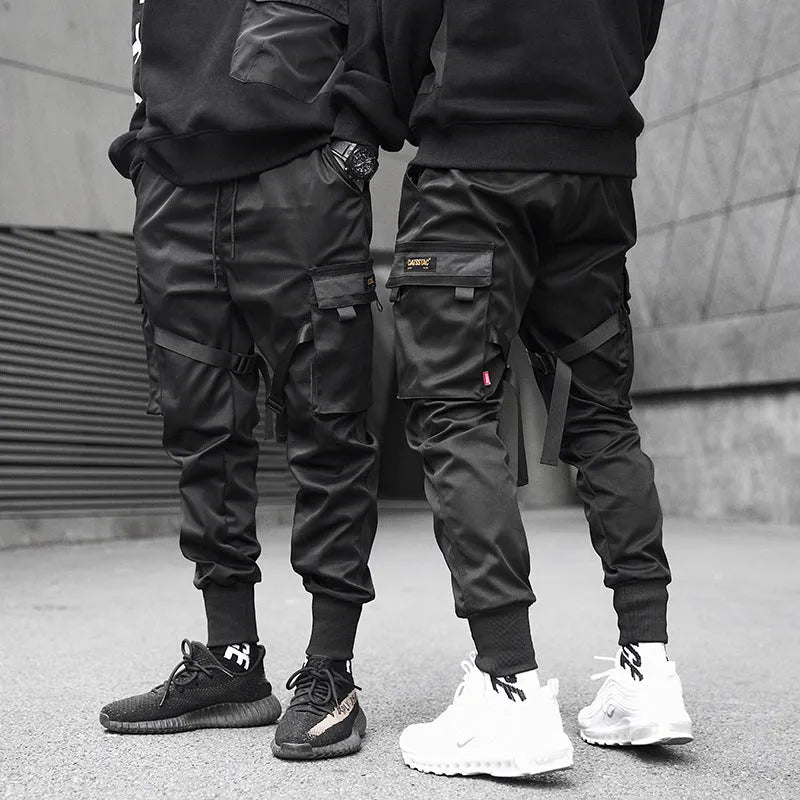 Black cotton cargo pants with tether closure, loose fit, ankle length, on a model