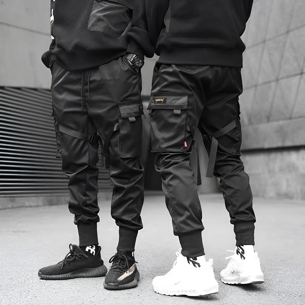 Black cotton cargo pants with tether closure, loose fit, ankle length, on a model