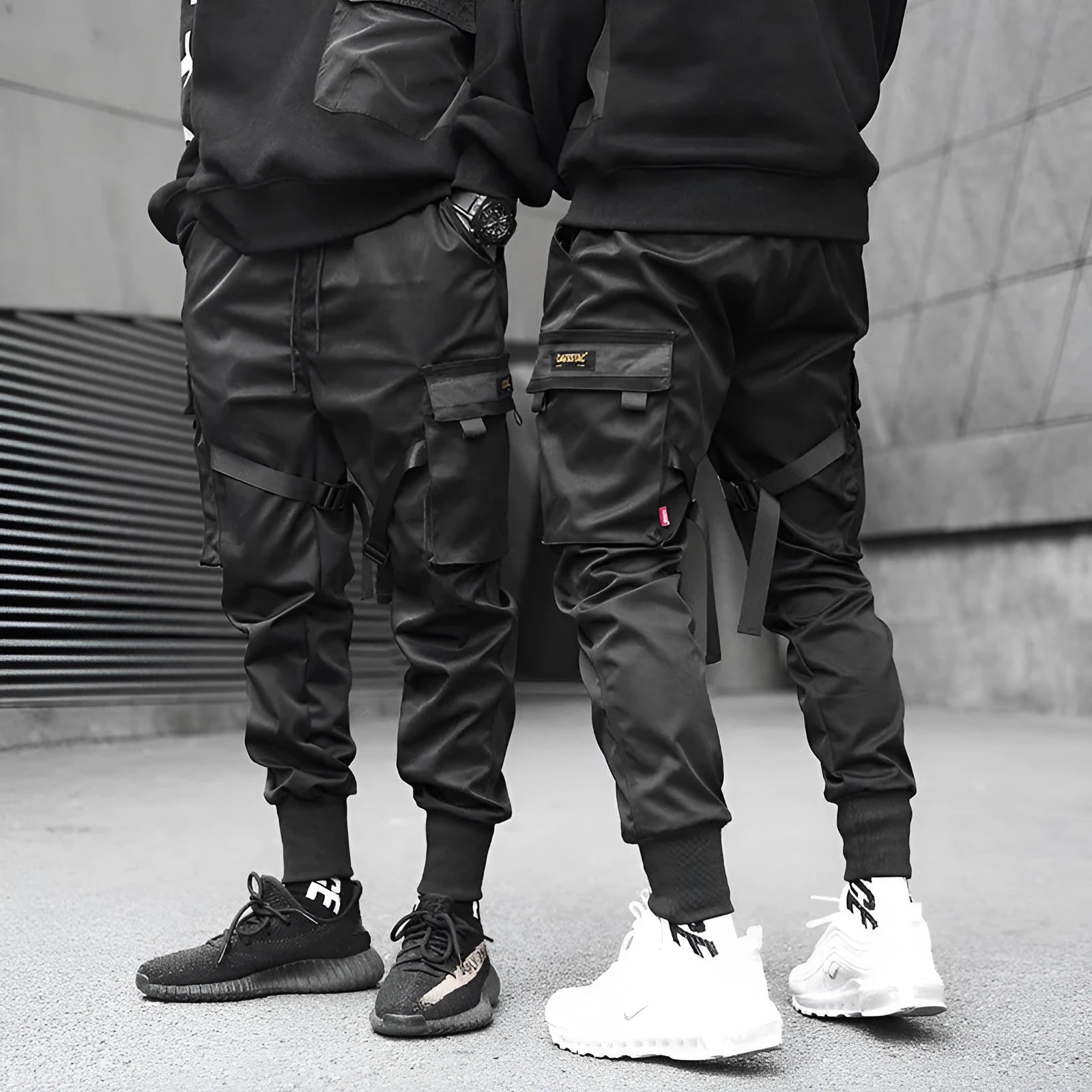 Black cotton cargo pants with tether closure, loose fit, ankle length, on a model