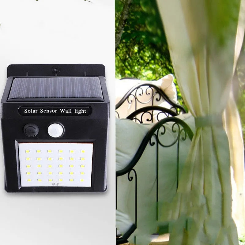 White solar-powered outdoor garden lamp with LED lights and a motion sensor on a black stake.