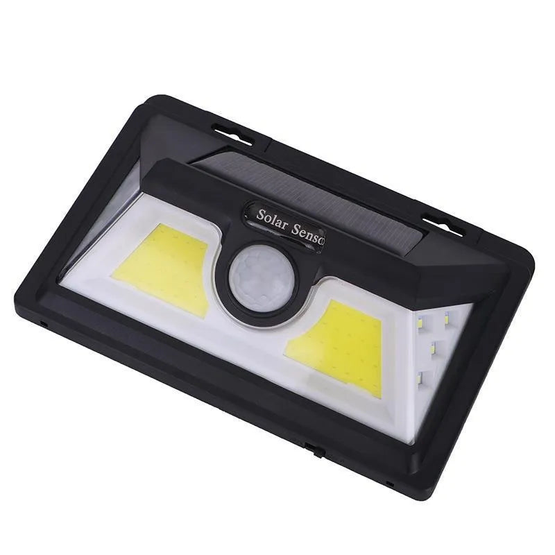 White solar-powered outdoor garden lamp with LED lights and a motion sensor on a black stake.
