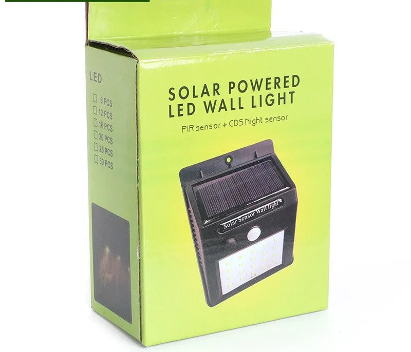 White solar-powered outdoor garden lamp with LED lights and a motion sensor on a black stake.